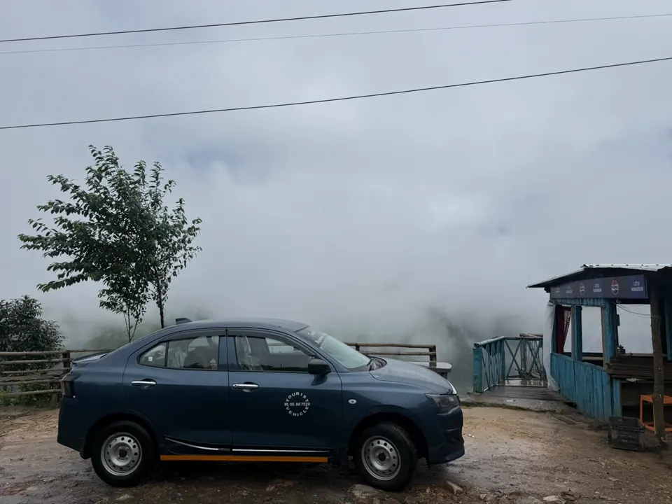 A PP The Traveller cab waiting at a misty hilltop viewpoint in Meghalaya