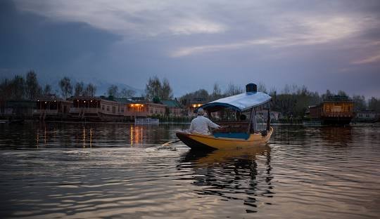 Traditional Shikaras and houseboats on Dal Lake surrounded by mountains in Srinagar